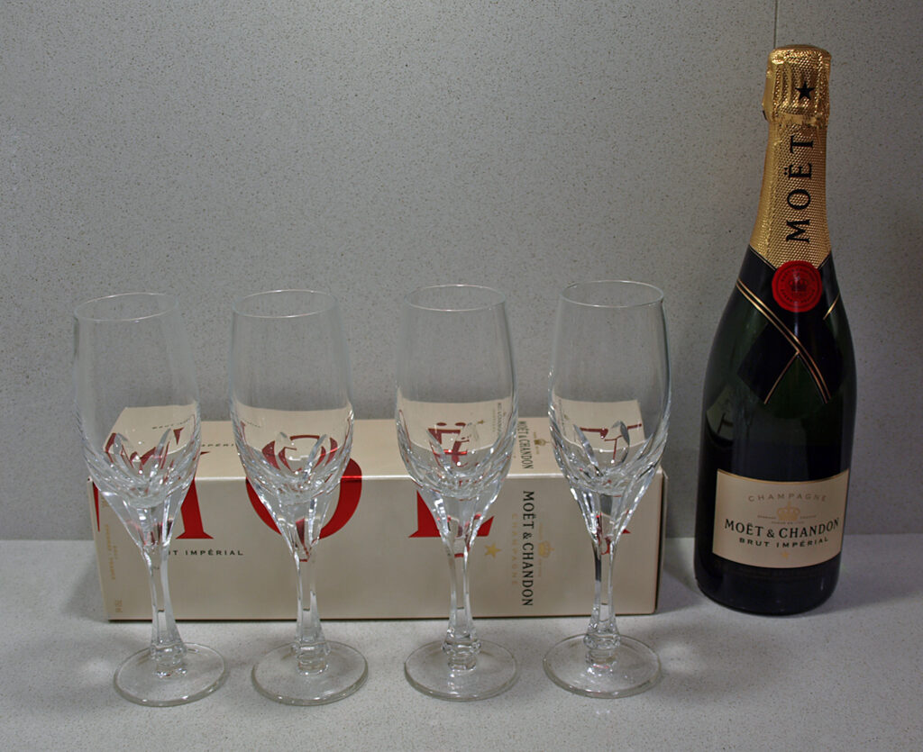 A labelled Moët & Chandon bottle beside four empty glasses
