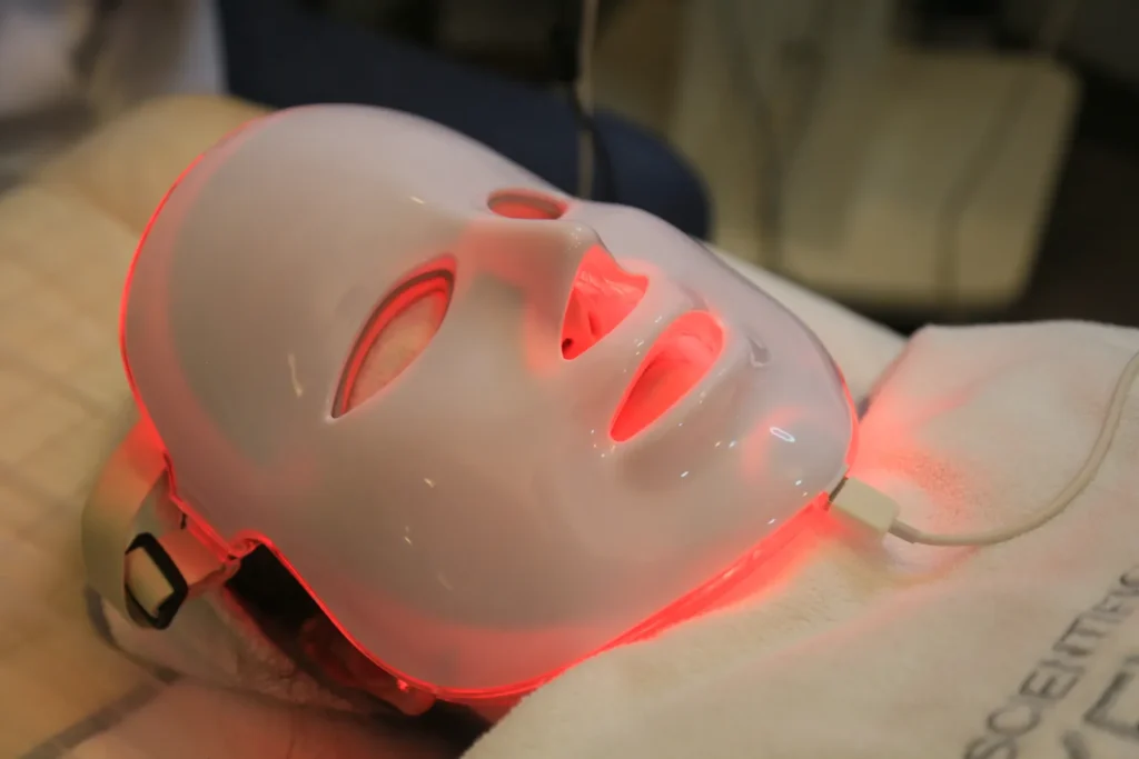 A person wearing an illuminated LED facial mask